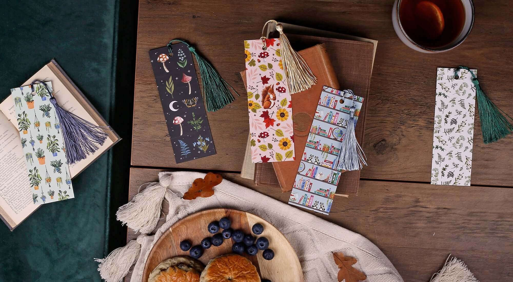 Beautiful Bookmarks displayed on a wooden table with tea and pastries, perfect for every book lover.