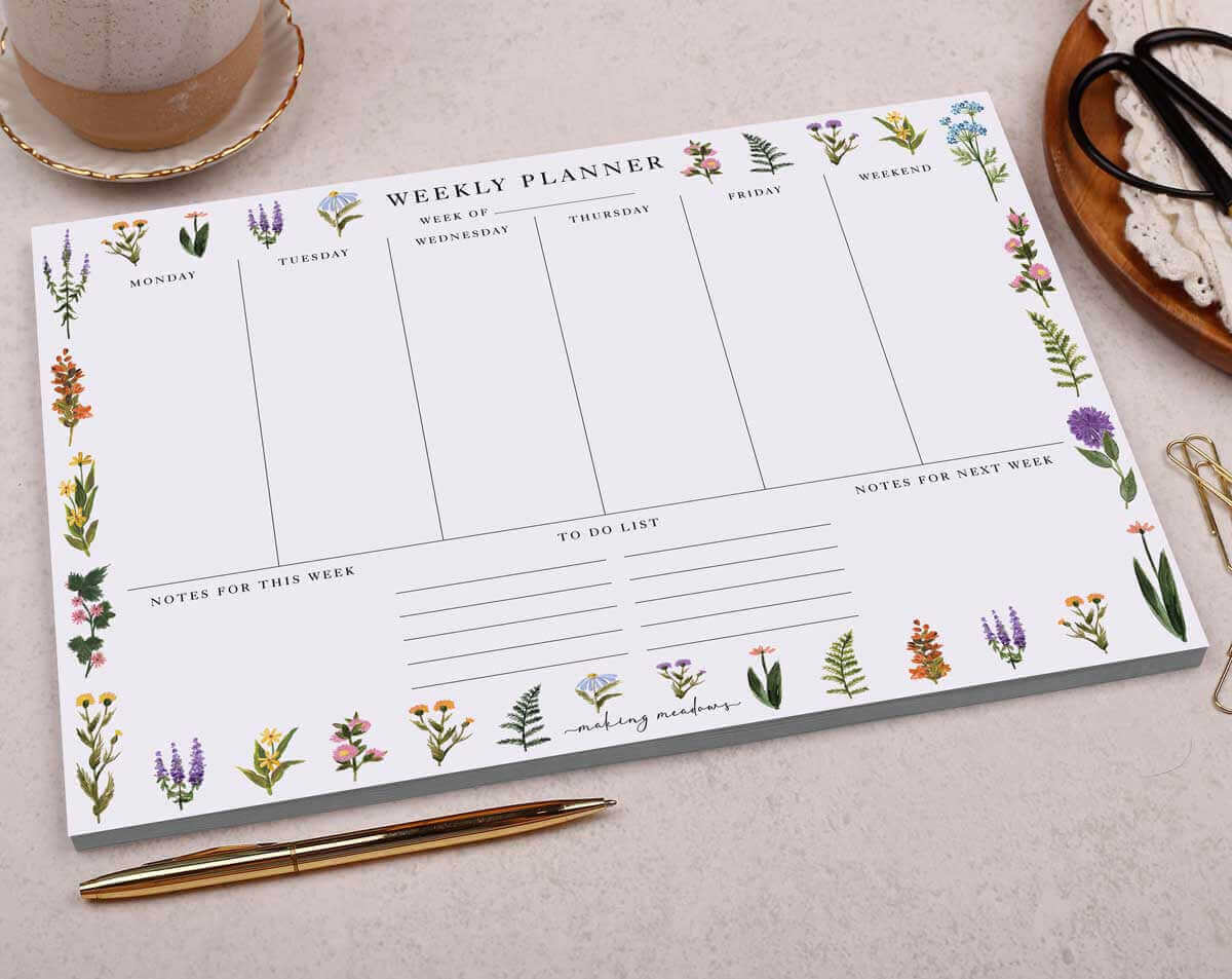 Organise Your Desk with a stylish weekly planner featuring floral designs for effective planning.