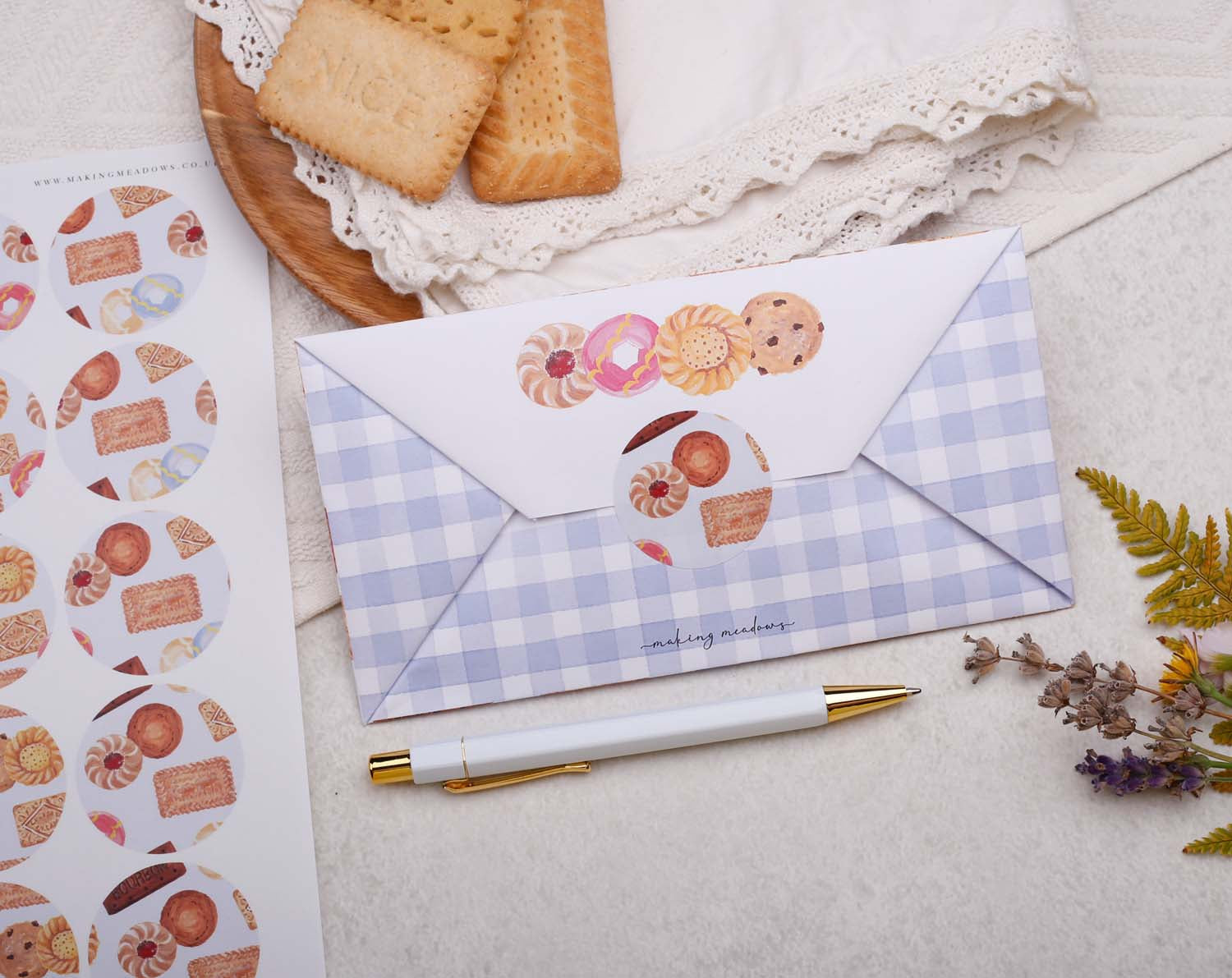 Eco-Friendly Stationery design with a cookie-themed envelope and stickers on a textured background.