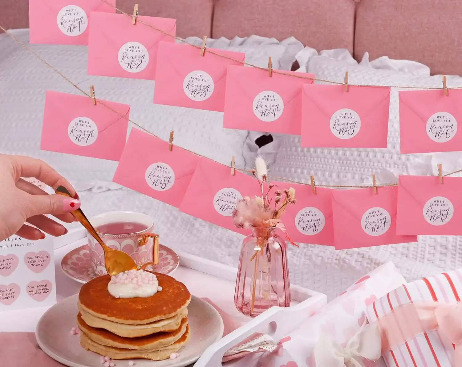 Celebrating Valentine's Day with pink stationery and pancakes on a cozy bed.