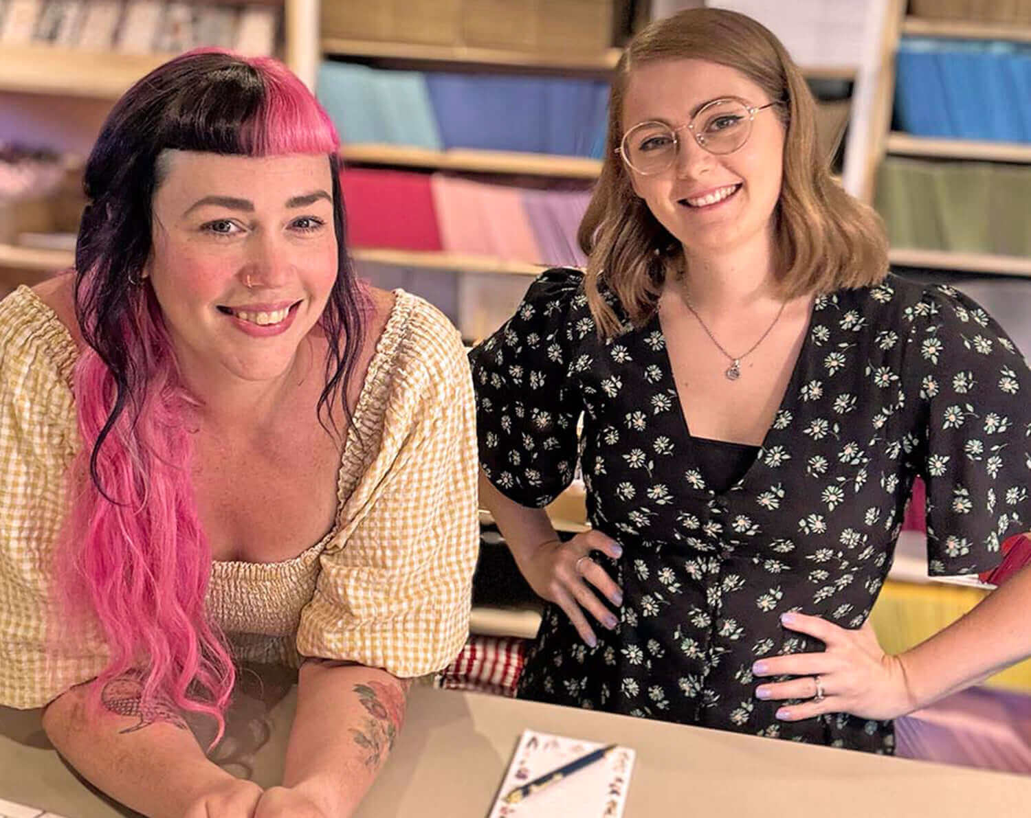 Two small business owners smiling at their shop, highlighting the benefits of Shopping Small.