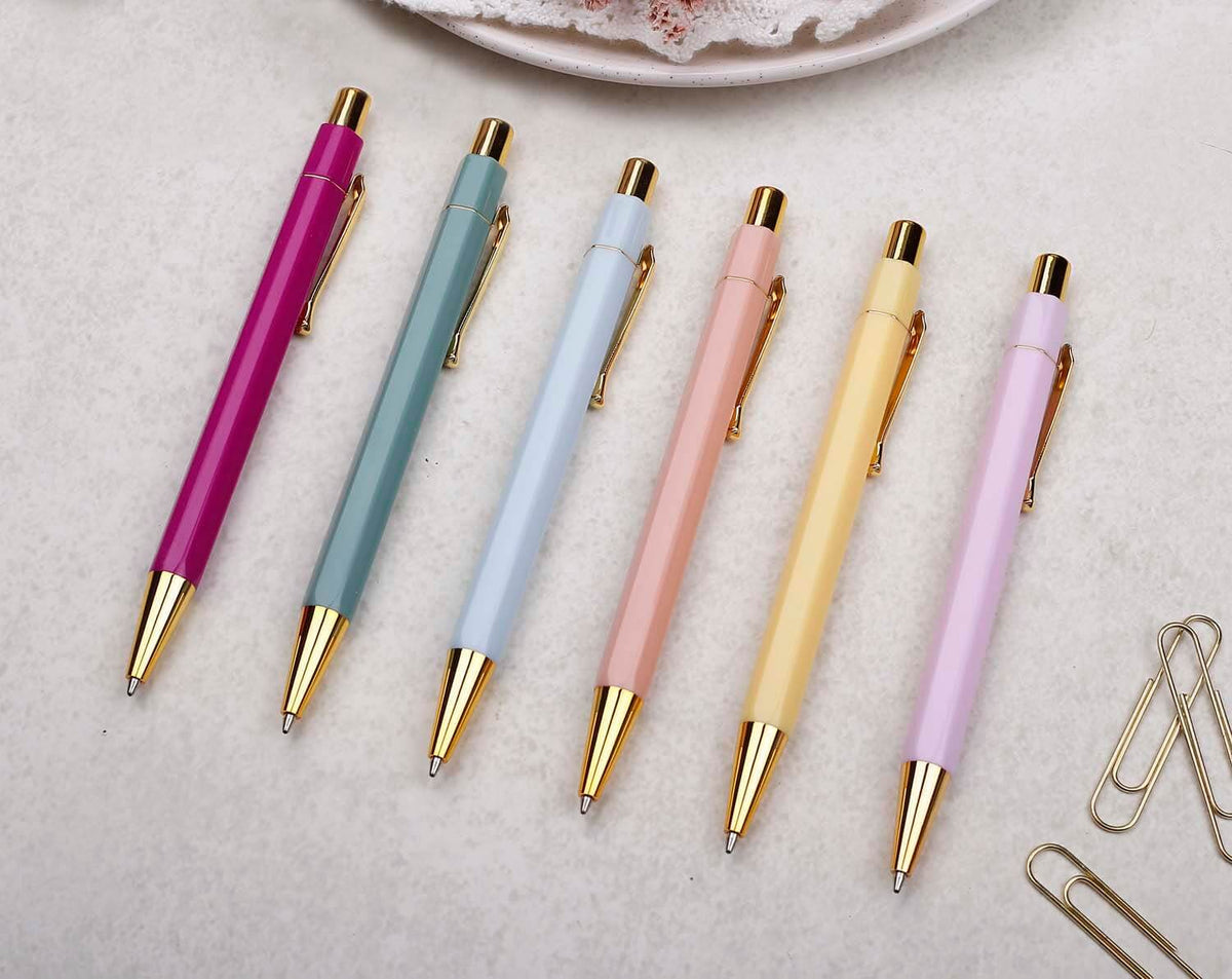 Collection of Ballpoint Pens in various colors with gold accents on a light background.
