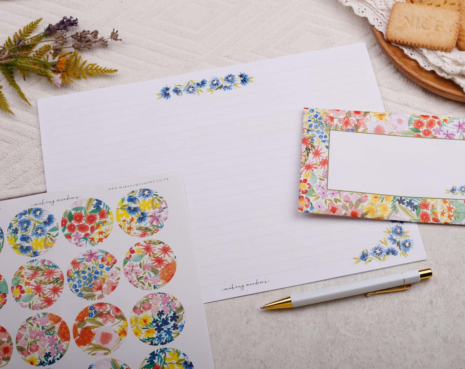 A4 origami writing paper with watercolor flowers, decorative stickers, and a pen on a table.