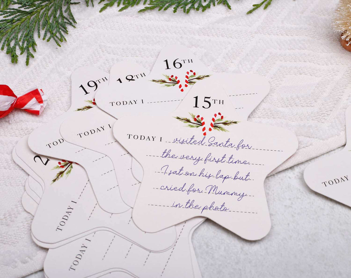 Close-up of Baby's First Christmas Advent keepsake cards featuring handwritten memories for each day of December.
