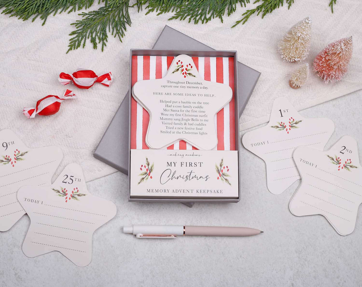 Image of Baby's First Christmas Advent Keepsake with memory cards and holiday decorations set on a table.