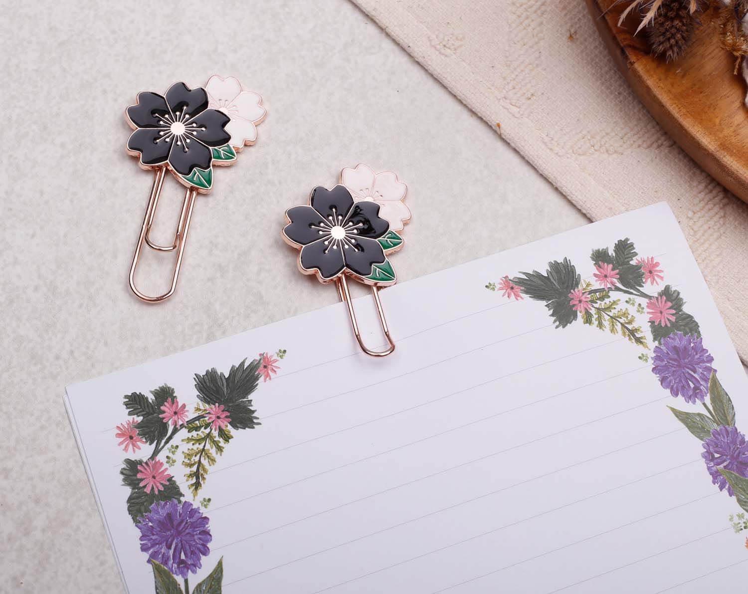 Black Flower Paper Clips on floral stationery, featuring pink and black enamel designs for elegant organization.