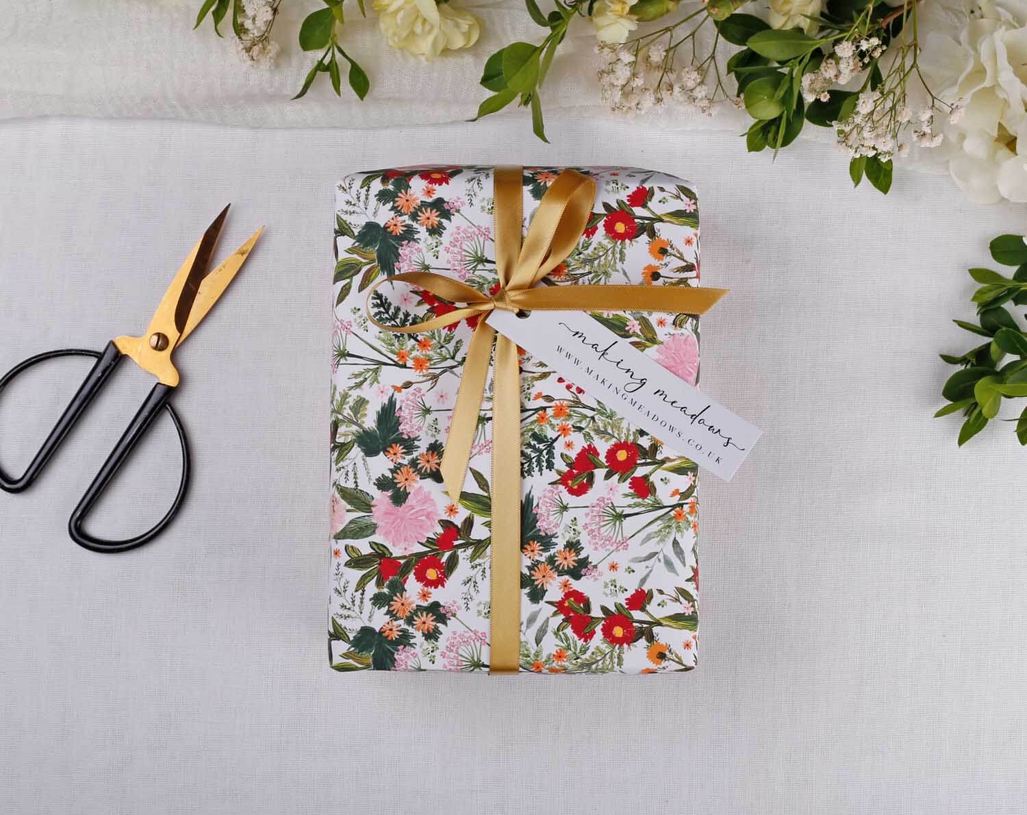 Boho Wedding Wrapping Paper beautifully wrapped with floral design and gold ribbon, perfect for wedding gifts.
