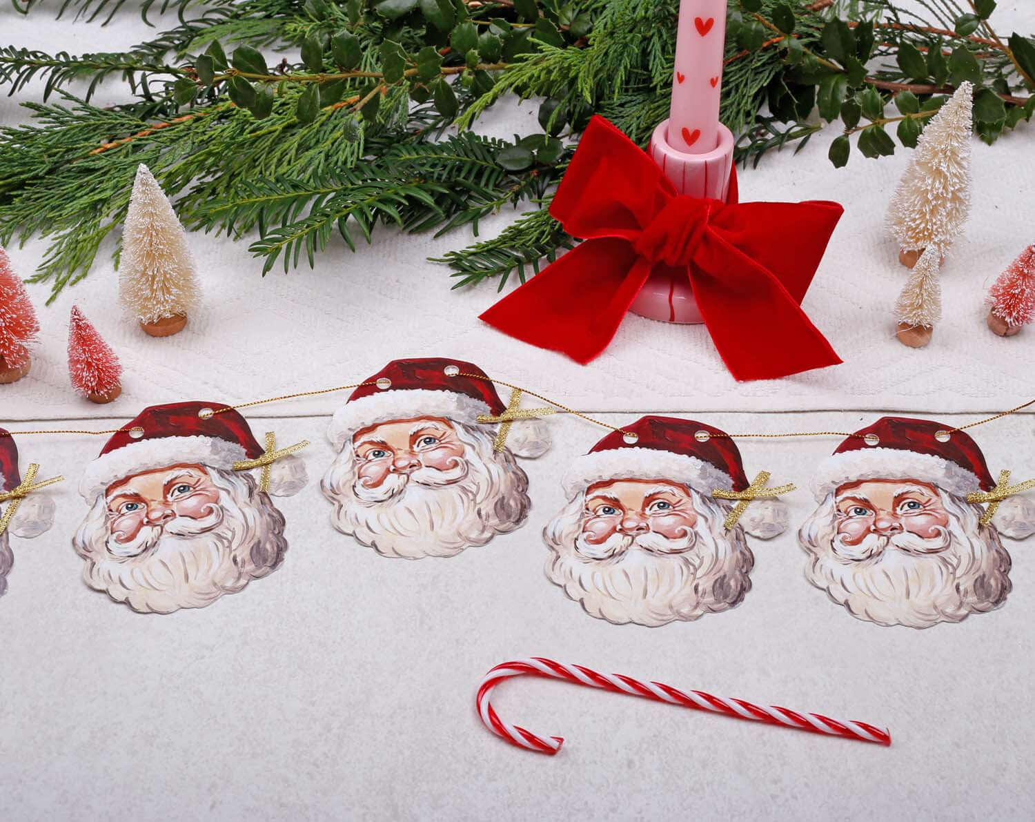 Father Christmas Bunting displayed with Christmas decorations and a candy cane, enhancing festive spirit.