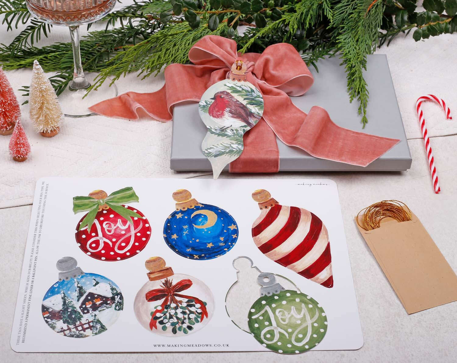 Bauble Christmas Gift Tags - 12 Pack featuring vibrant ornament illustrations on a gift box with festive decorations.