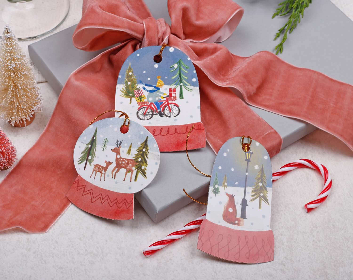 Snow Globe Christmas Gift Tags featuring festive designs of deer, bike, and winter scenes on decorative holiday gift packaging.