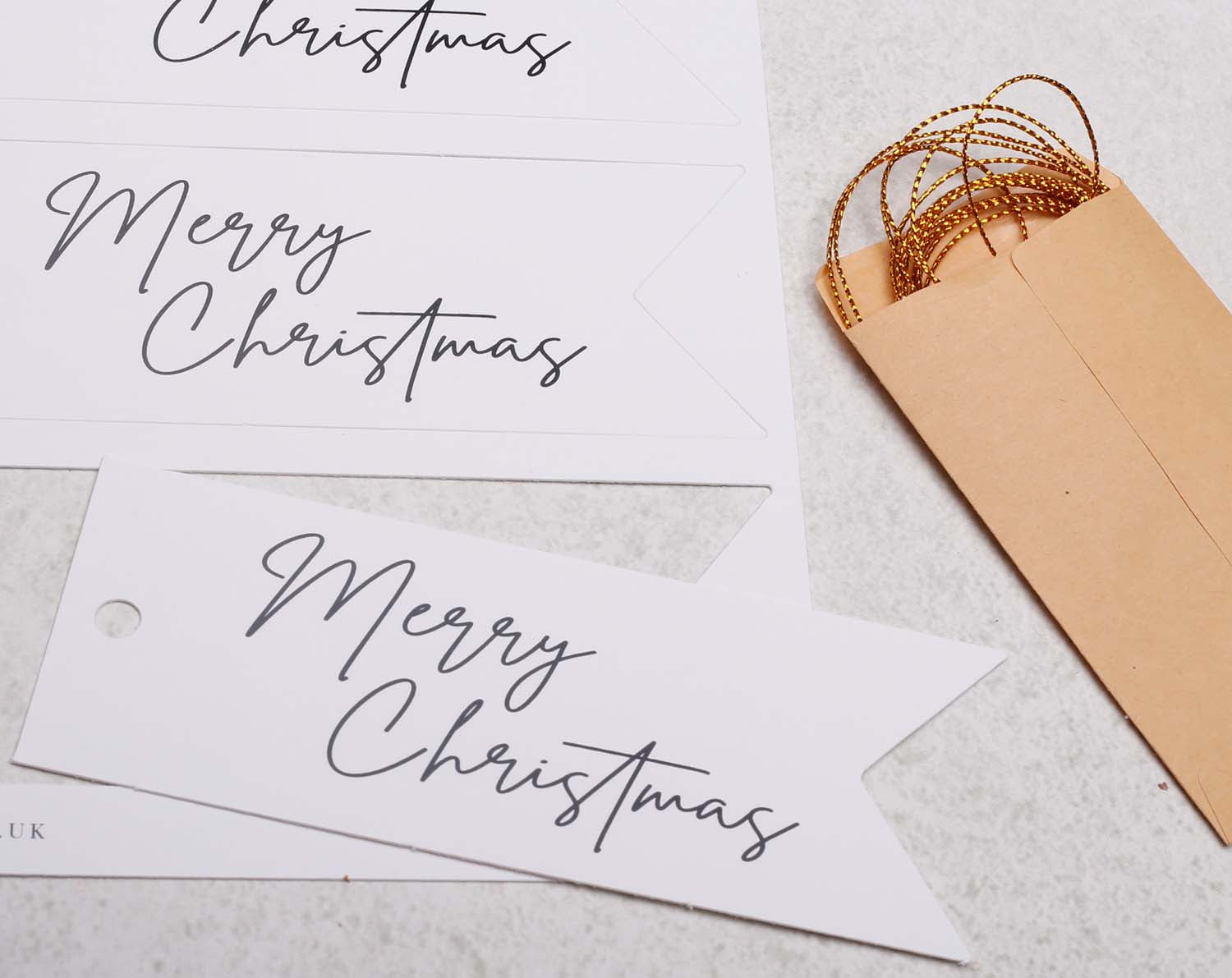 Merry Christmas Gift Tags featuring elegant typography with an envelope and golden string decoration.