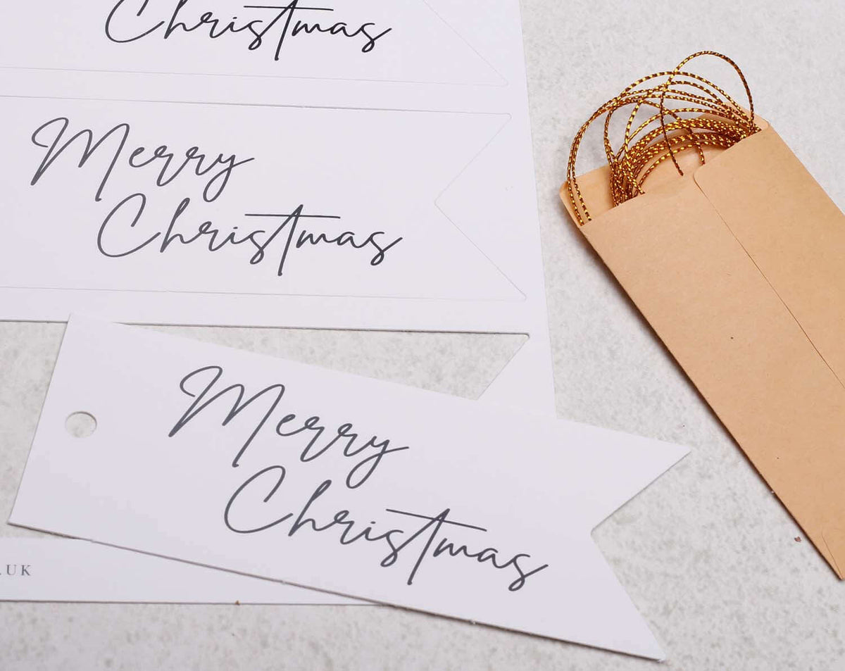 Merry Christmas Gift Tags featuring elegant typography with an envelope and golden string decoration.