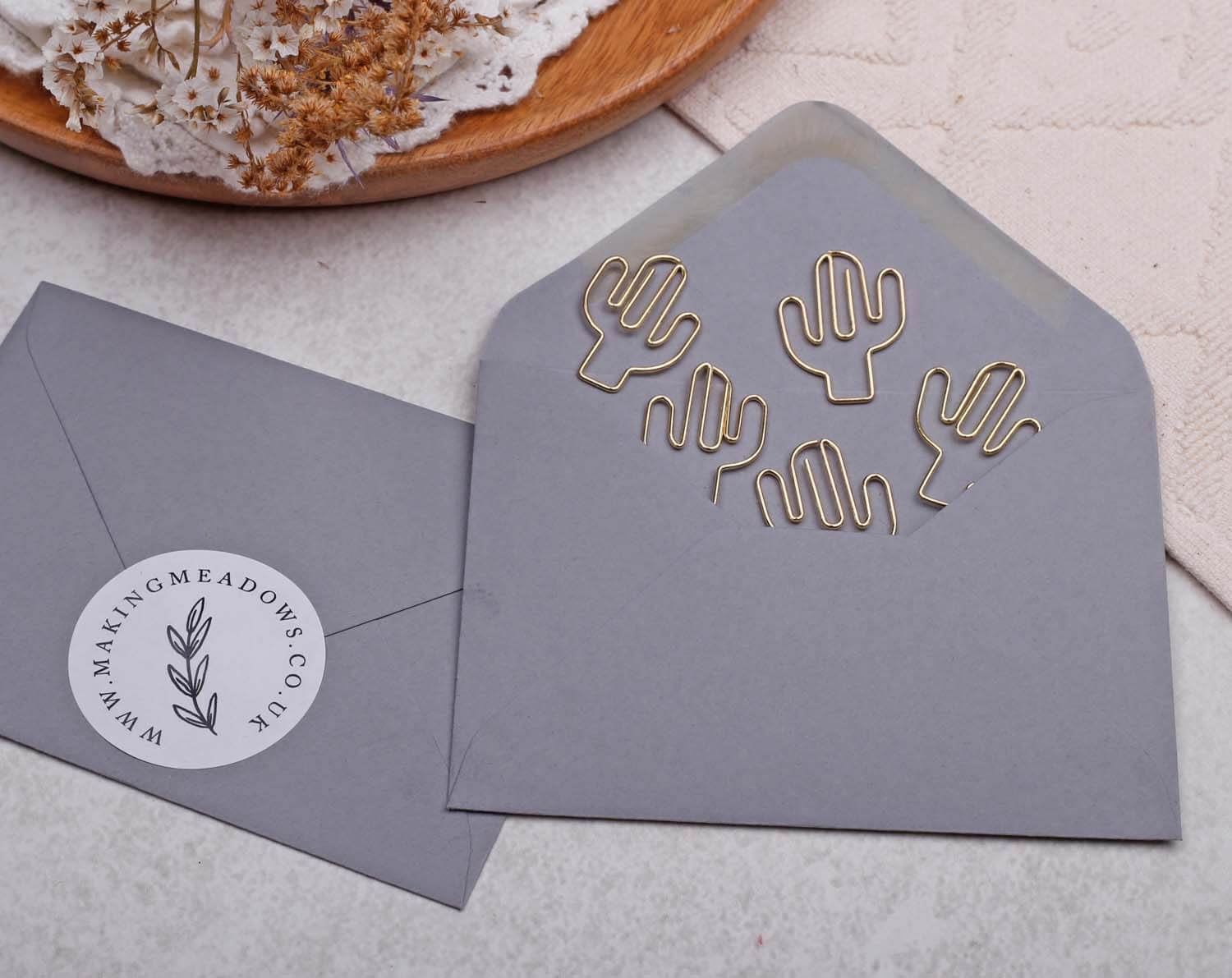 Gold Cactus Paper Clips displayed in a grey envelope on a textured surface, perfect for cheerful stationery.