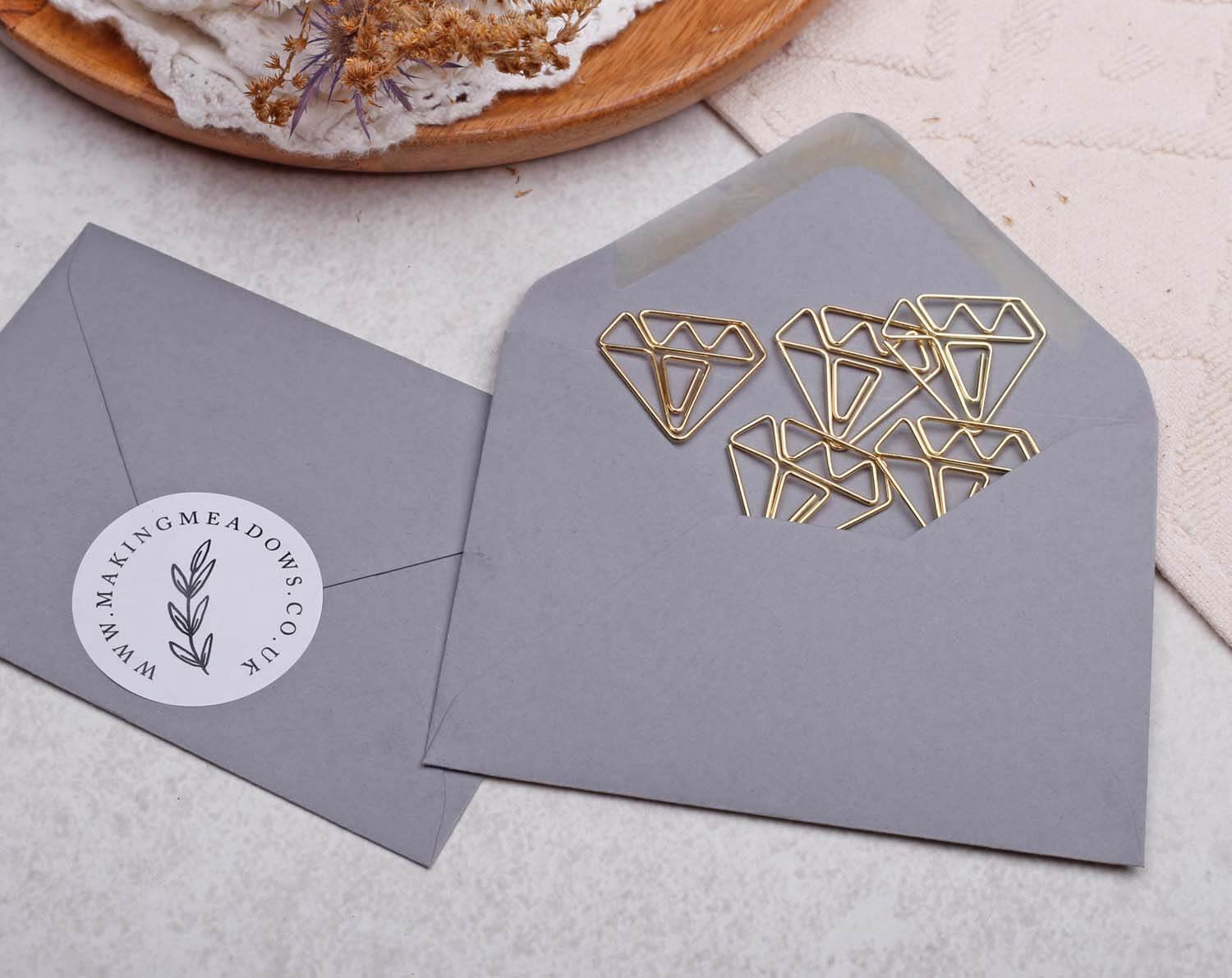 Gold Gem Paper Clips in a gray envelope showcasing unique gem-shaped design for stylish stationery.