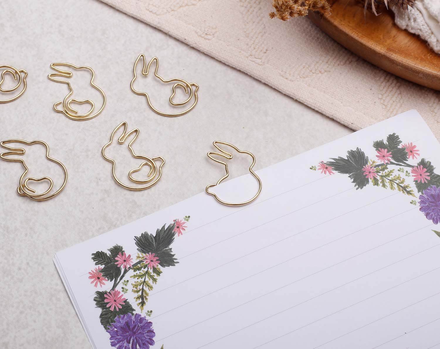 Gold Rabbit Paper Clips arranged on a floral notepad, adding charm and playfulness to your stationery.
