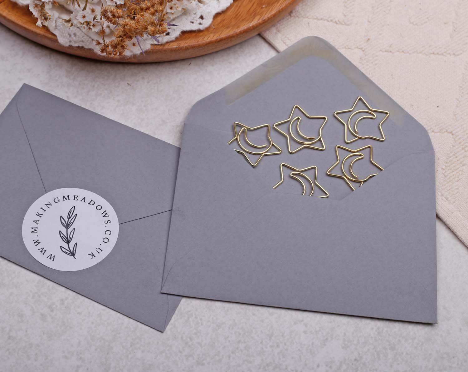 Gold Star Paper Clips displayed in an envelope, showcasing their unique star shape and shiny gold finish.