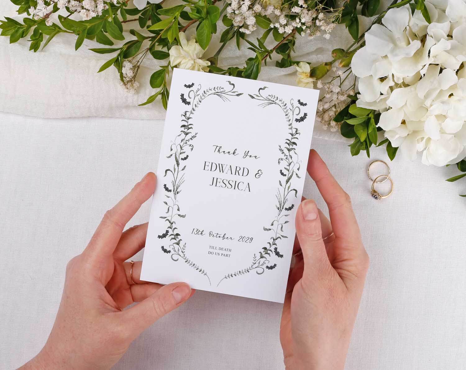 Gothic Wedding Thank You Cards held by hands, featuring floral design and names Edward & Jessica with wedding date.