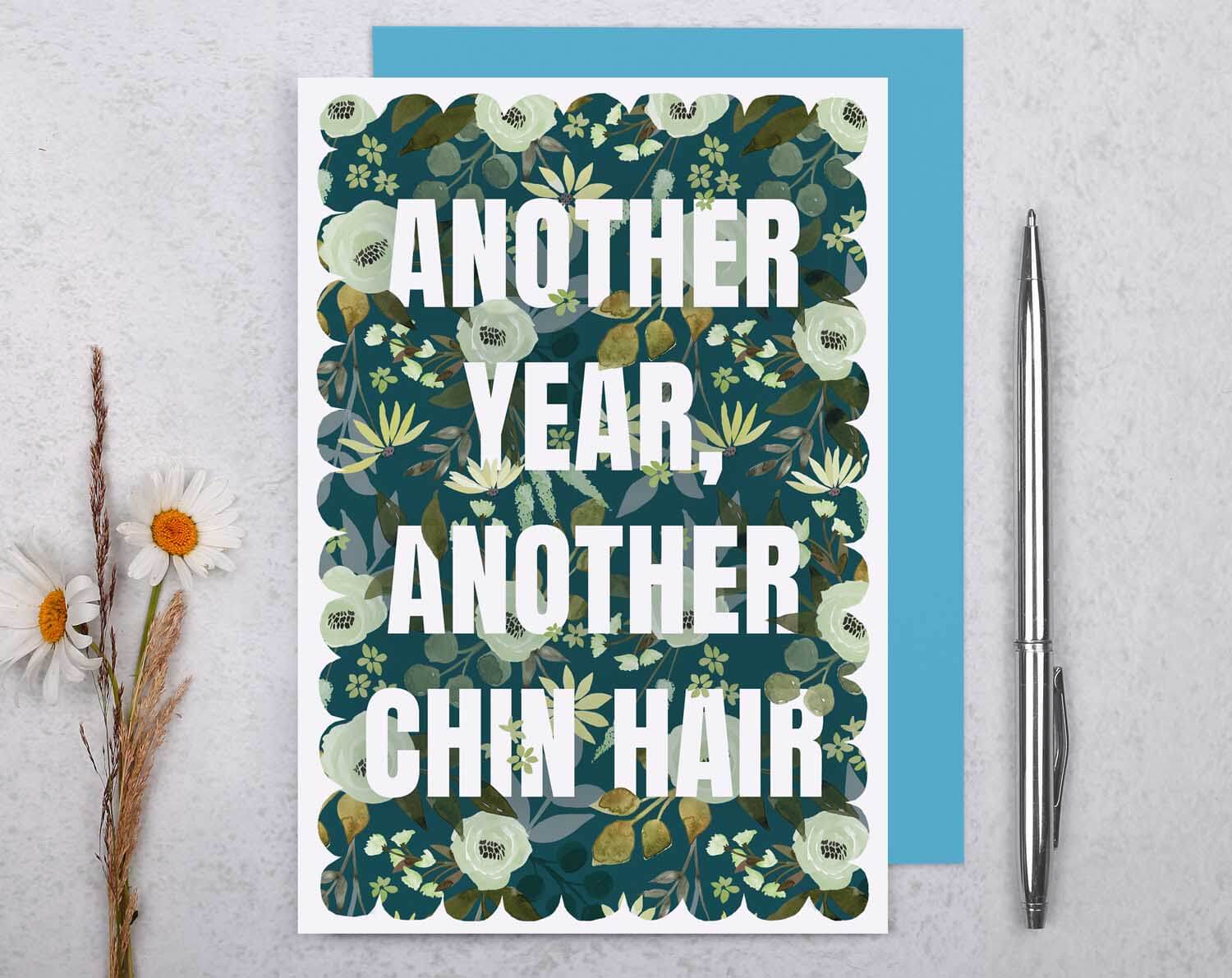 Joke Birthday Card featuring bold text "Another Year, Another Chin Hair" on a floral background.