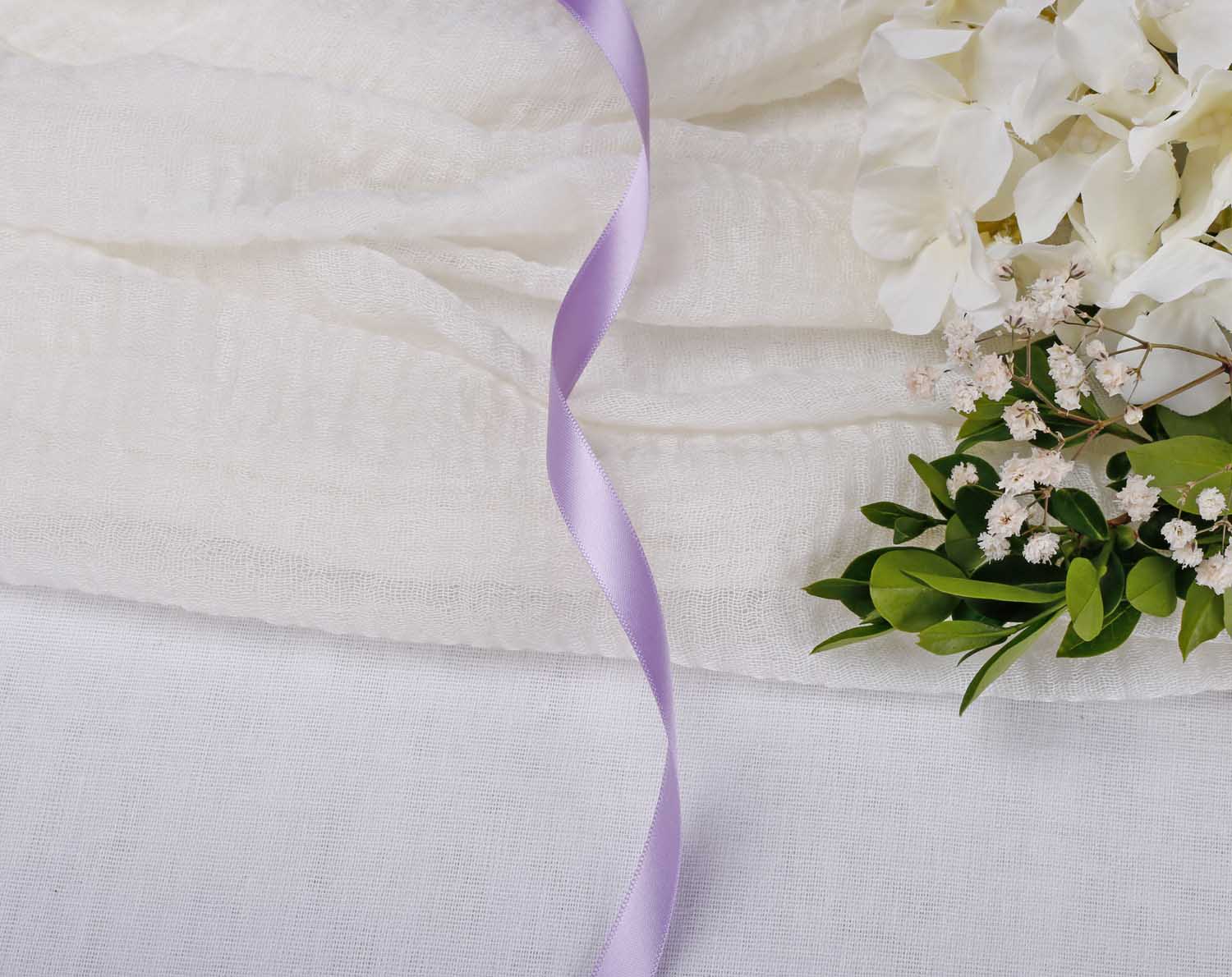 Lilac Satin Ribbon For Wedding beautifully arranged on a soft white surface with flowers nearby.
