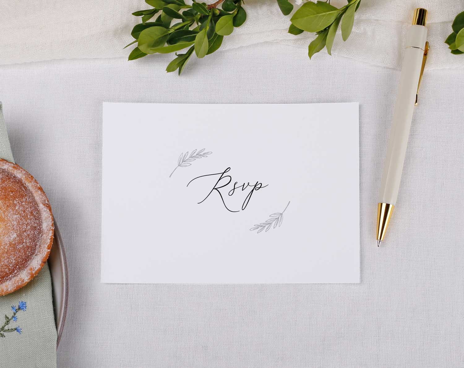 Minimalist Wedding RSVP Cards with elegant typography and decorative leaves on a soft fabric background.