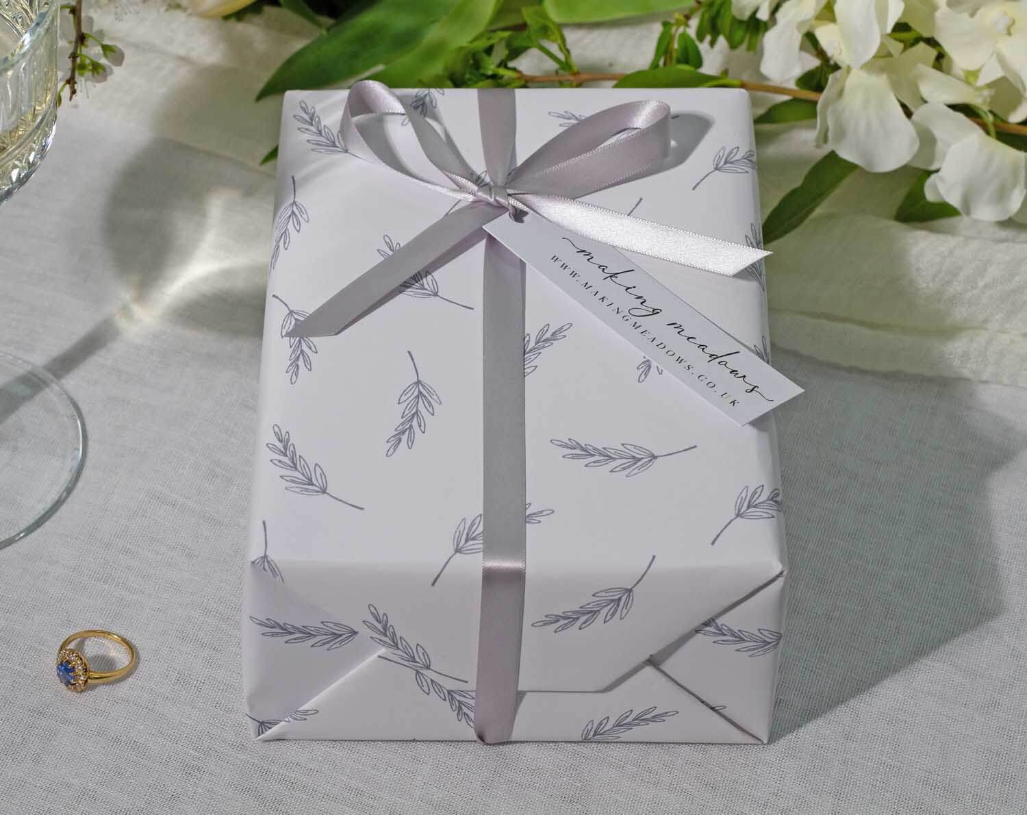 Minimalist Wedding Wrapping Paper featuring elegant leaf designs and a satin ribbon on a beautifully wrapped gift.