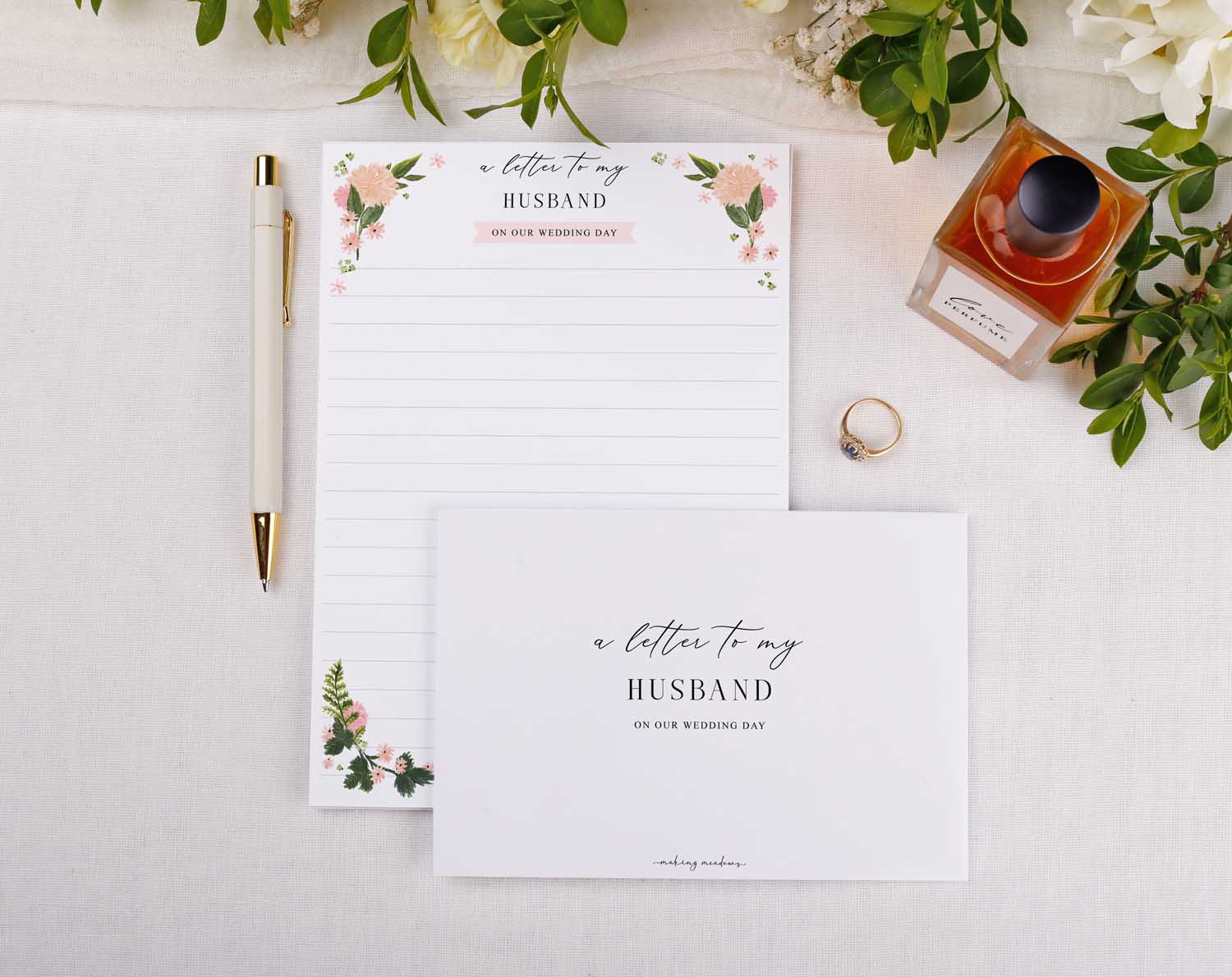 Pink Floral Wedding Letter to My Husband on a stylish desk with a pen, ring, and perfume.