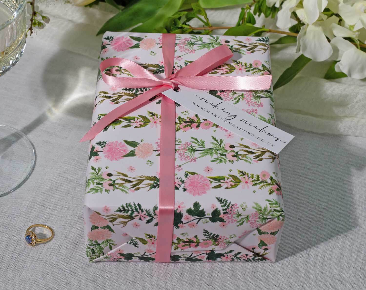 Pink Floral Wedding Wrapping Paper beautifully decorated gift with a pink ribbon and floral design, perfect for weddings.