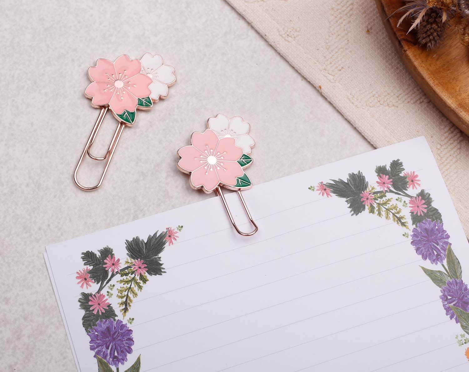 Pink Flower Paper Clips on a notepad, featuring delicate enamel flowers and rose gold metal clips.