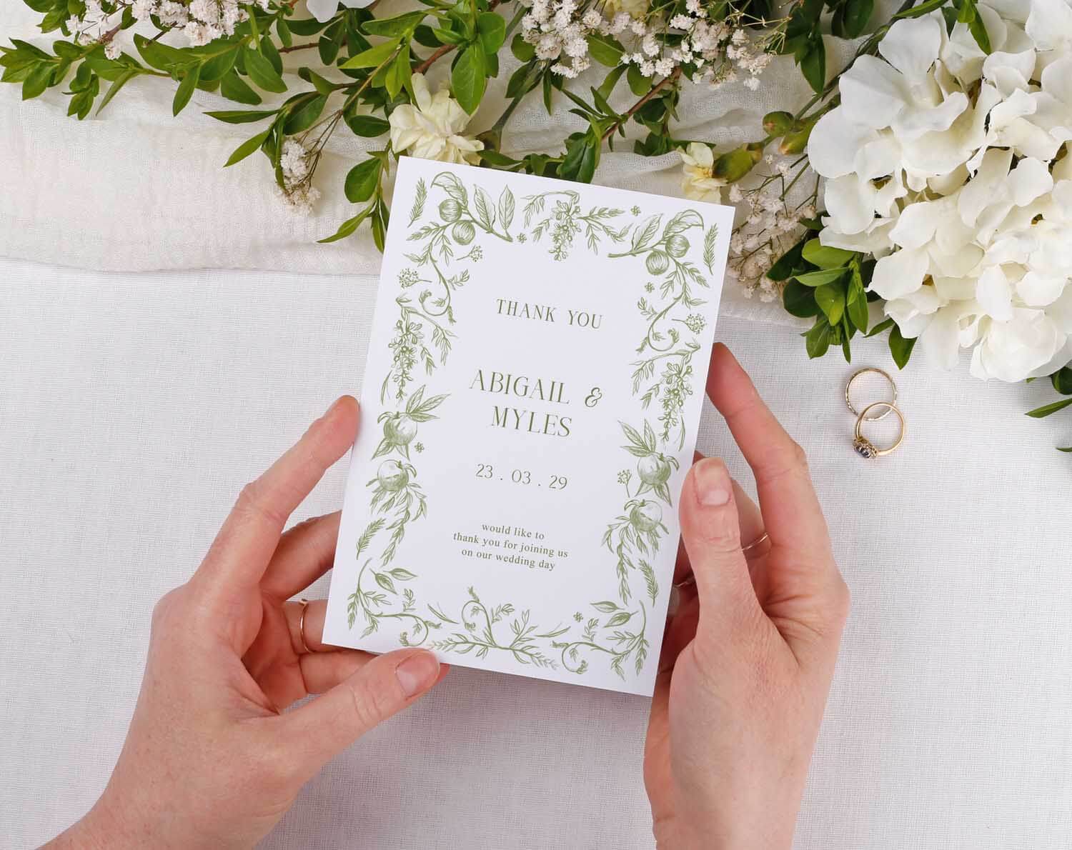 Sage Garden Wedding Thank You Cards held by hands with floral design, expressing gratitude after a wedding.