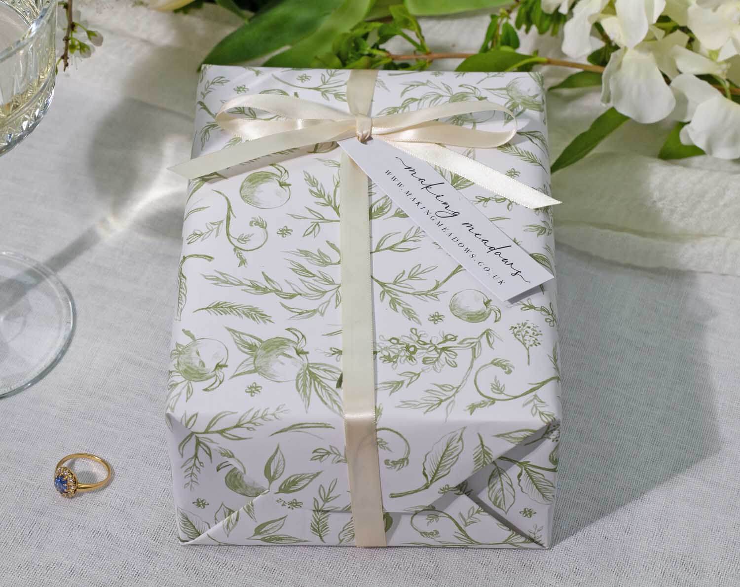 Sage Garden Wedding Wrapping Paper elegantly wrapped gift with floral design and ribbon, perfect for special occasions.