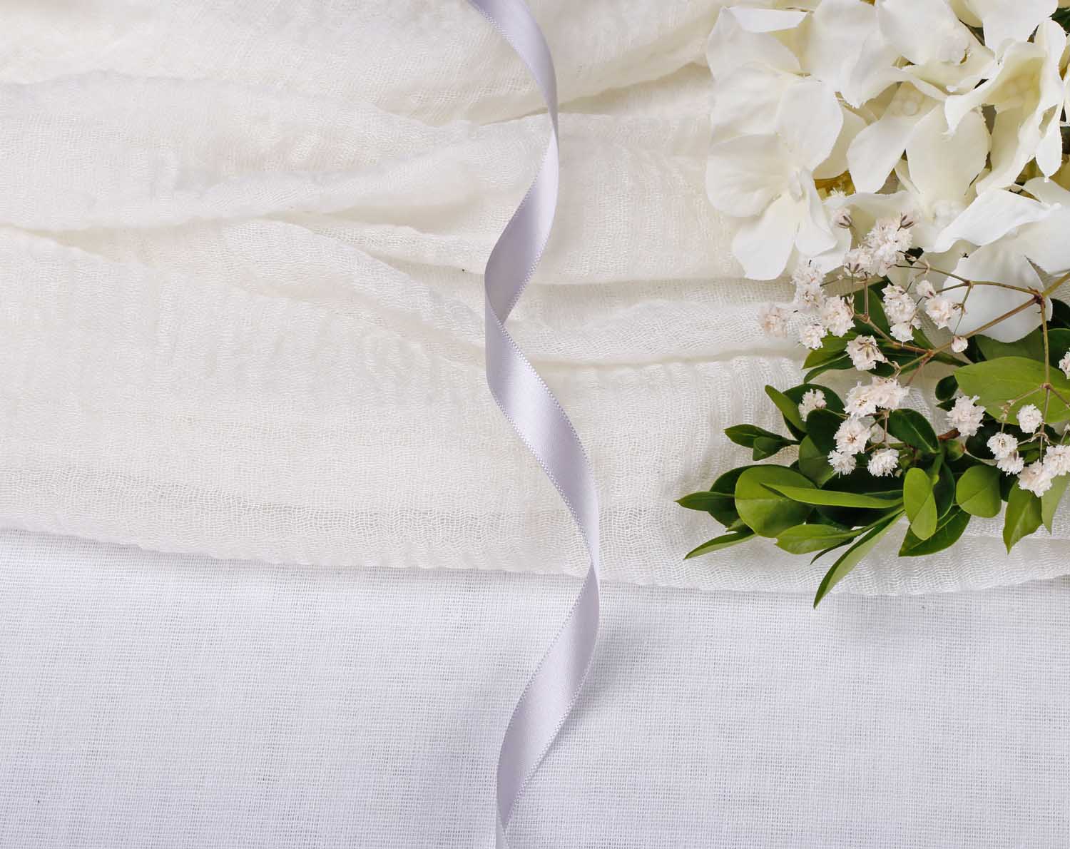 Silver Grey Satin Ribbon For Wedding elegantly displayed with white fabric and fresh flowers.