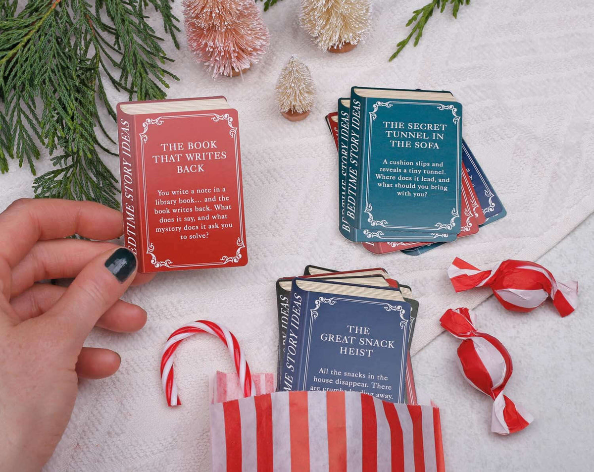 Hands holding story cards from the Story Book Idea Advent Calendar, featuring creative bedtime stories.