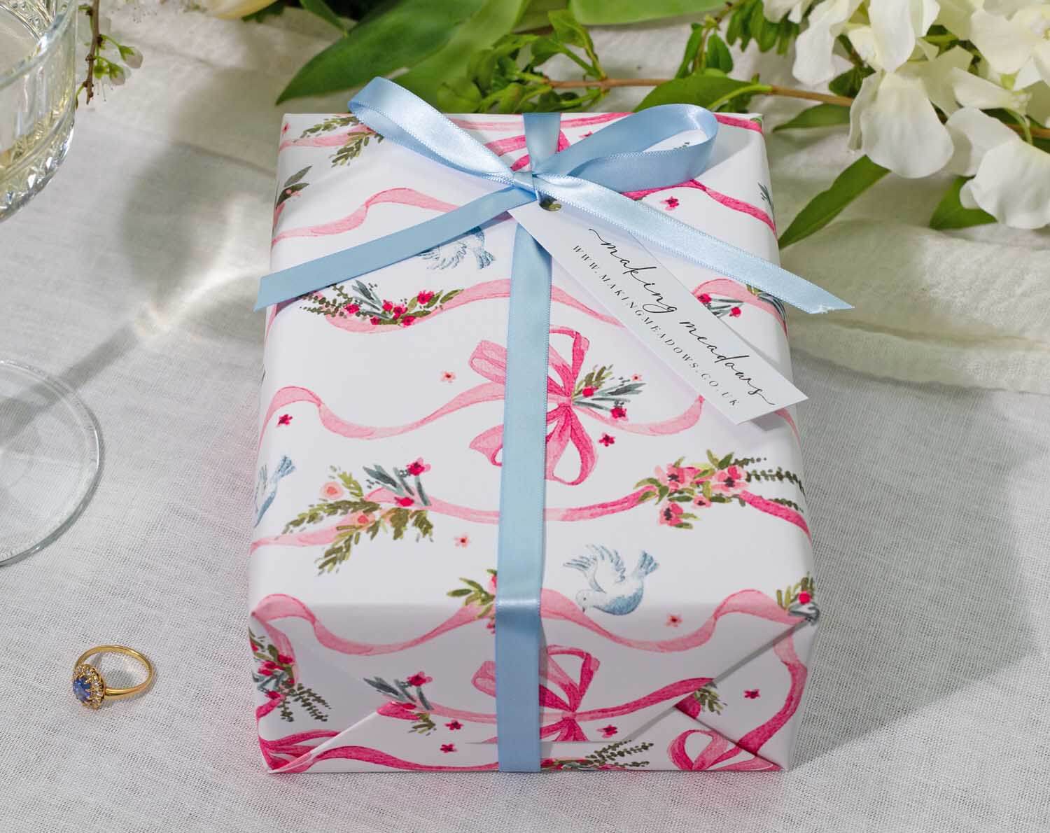 Vintage Wedding Wrapping Paper beautifully wraps a gift, adorned with floral designs and ribbons, perfect for weddings and engagements.