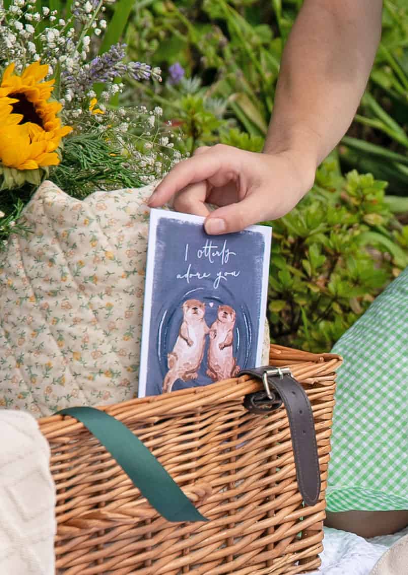 lady pulling an anniversary card out of a picnic basket