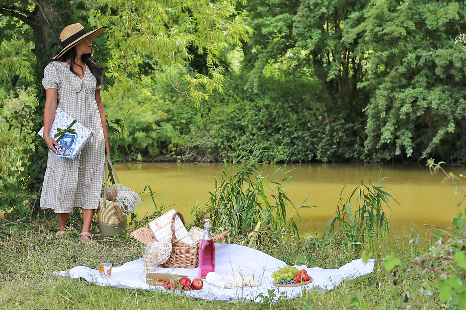 girl standing by river with making meadows wrapping paper around a stationery gift