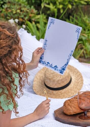 lady holding a luxurious a4 writing paper sheet with pretty blue floral design