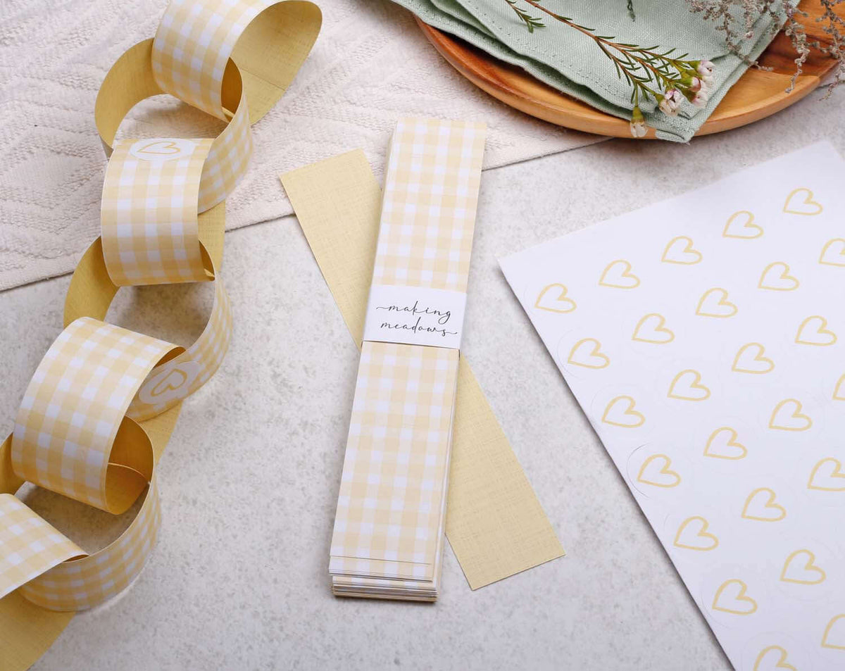 Yellow Gingham Paper Chains garland displayed with yellow stationery and heart-patterned paper.
