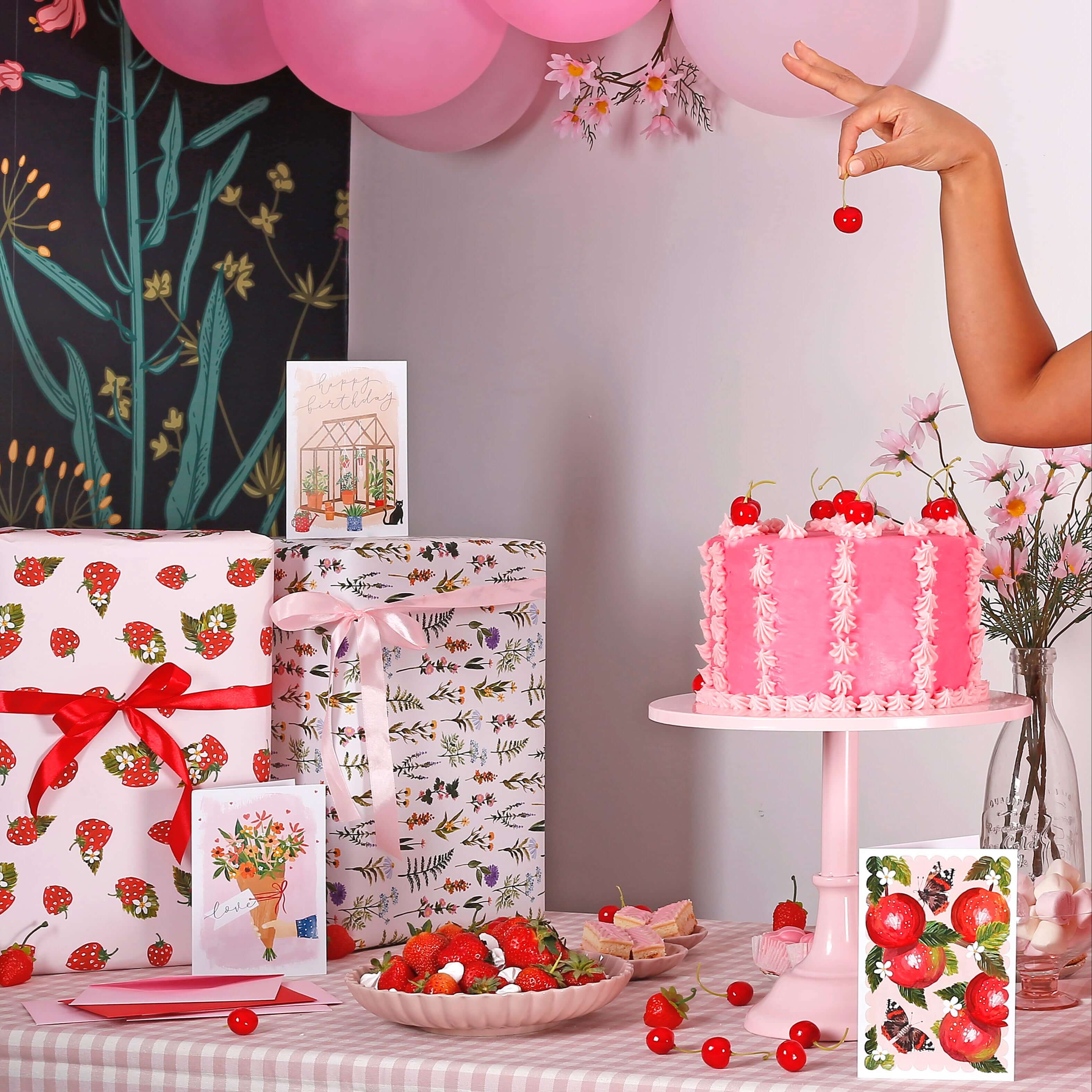 girl picking cherry off cake, surrounded by beautiful wrapping paper