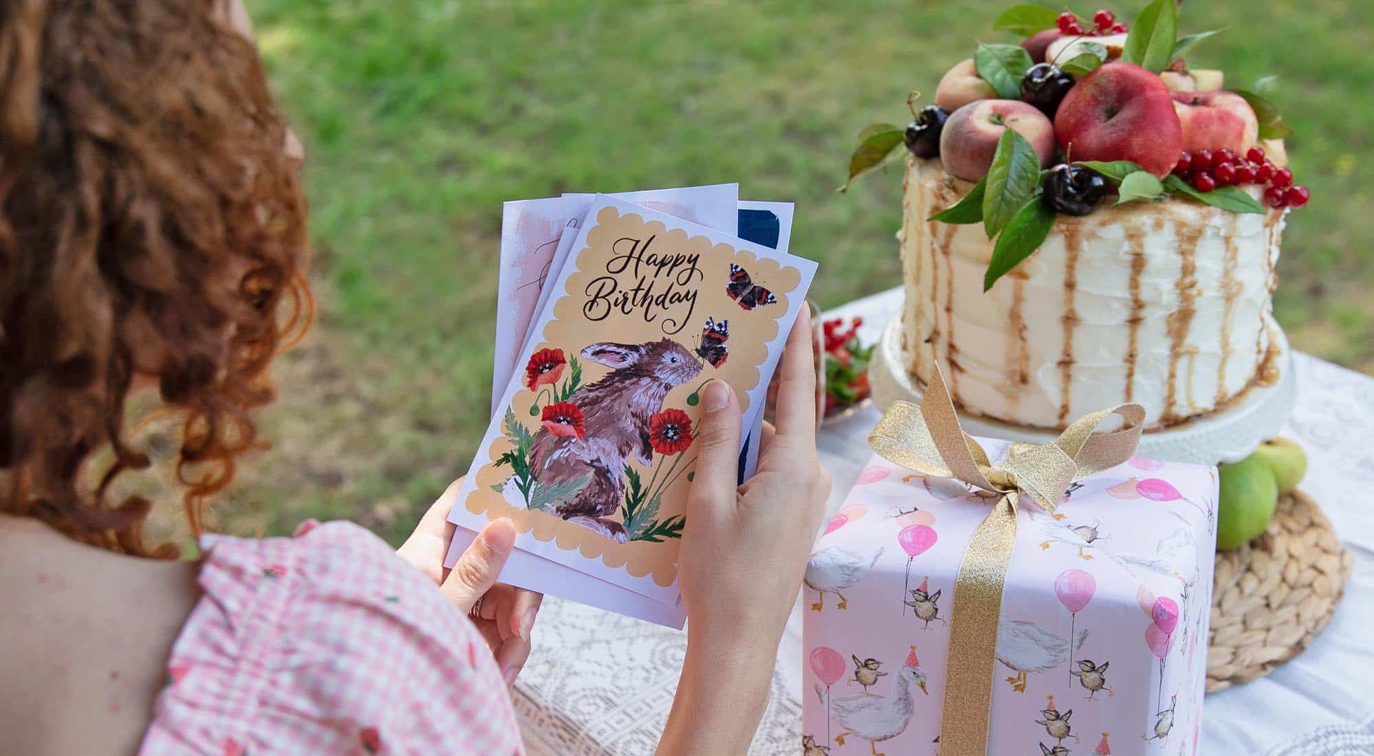 girl holding a handful of premium greeting cards designed by making meadows
