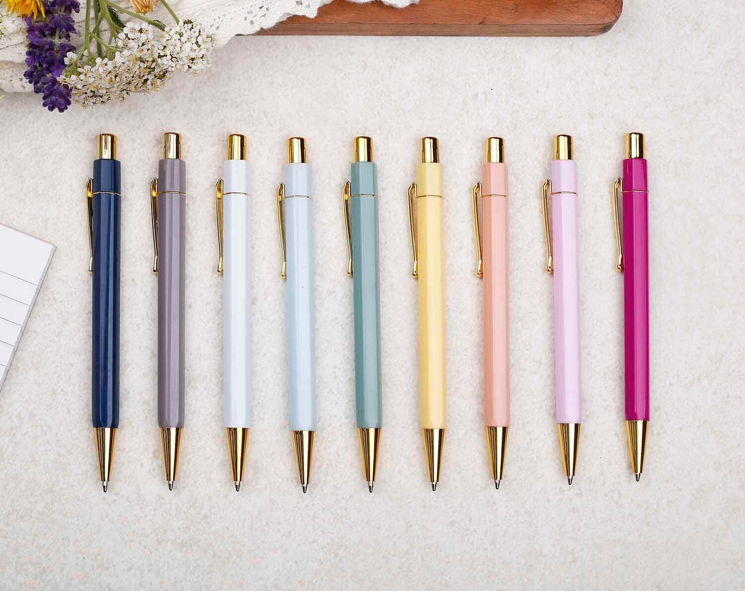 Colorful pens lined up with flowers and stationery, perfect for sharing Stationery Quotes.