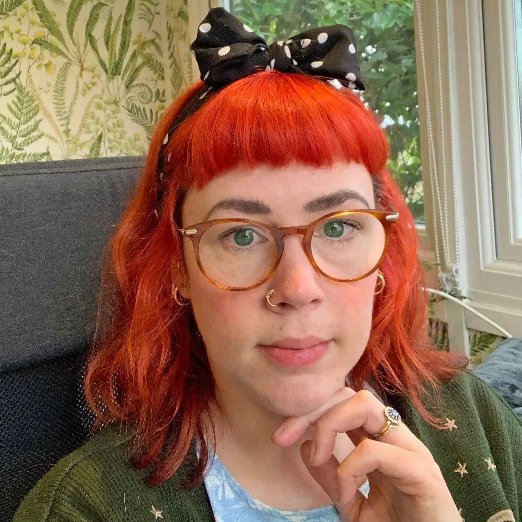 How To Start A Stationery Business - Young woman with red hair and glasses contemplating entrepreneurship.