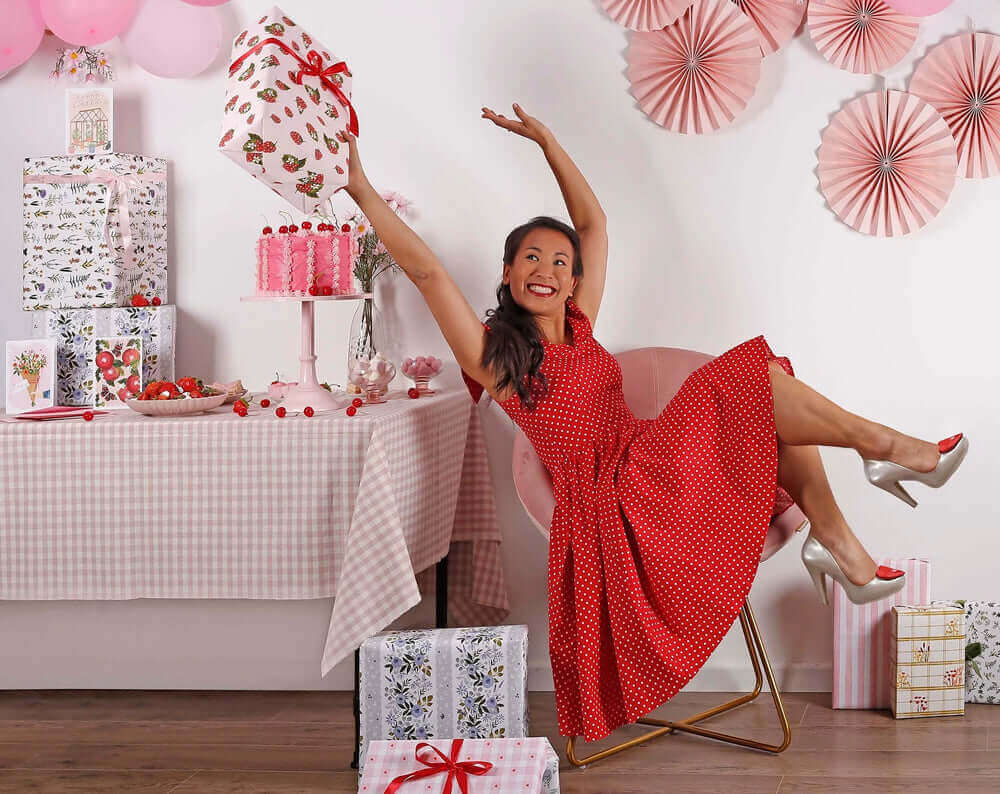 A woman in a red polka dot dress celebrates Valentine's Day, ready to spice up Valentines Day with surprises.
