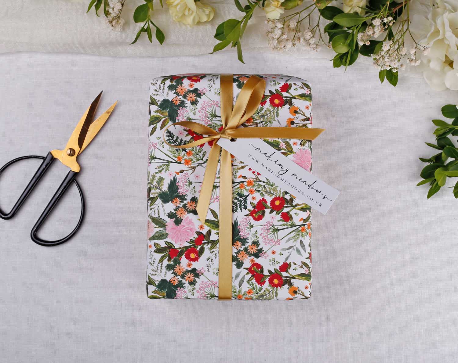 Wedding Day Gifts for Your Bridal Party beautifully wrapped with flowers, scissors, and greenery.