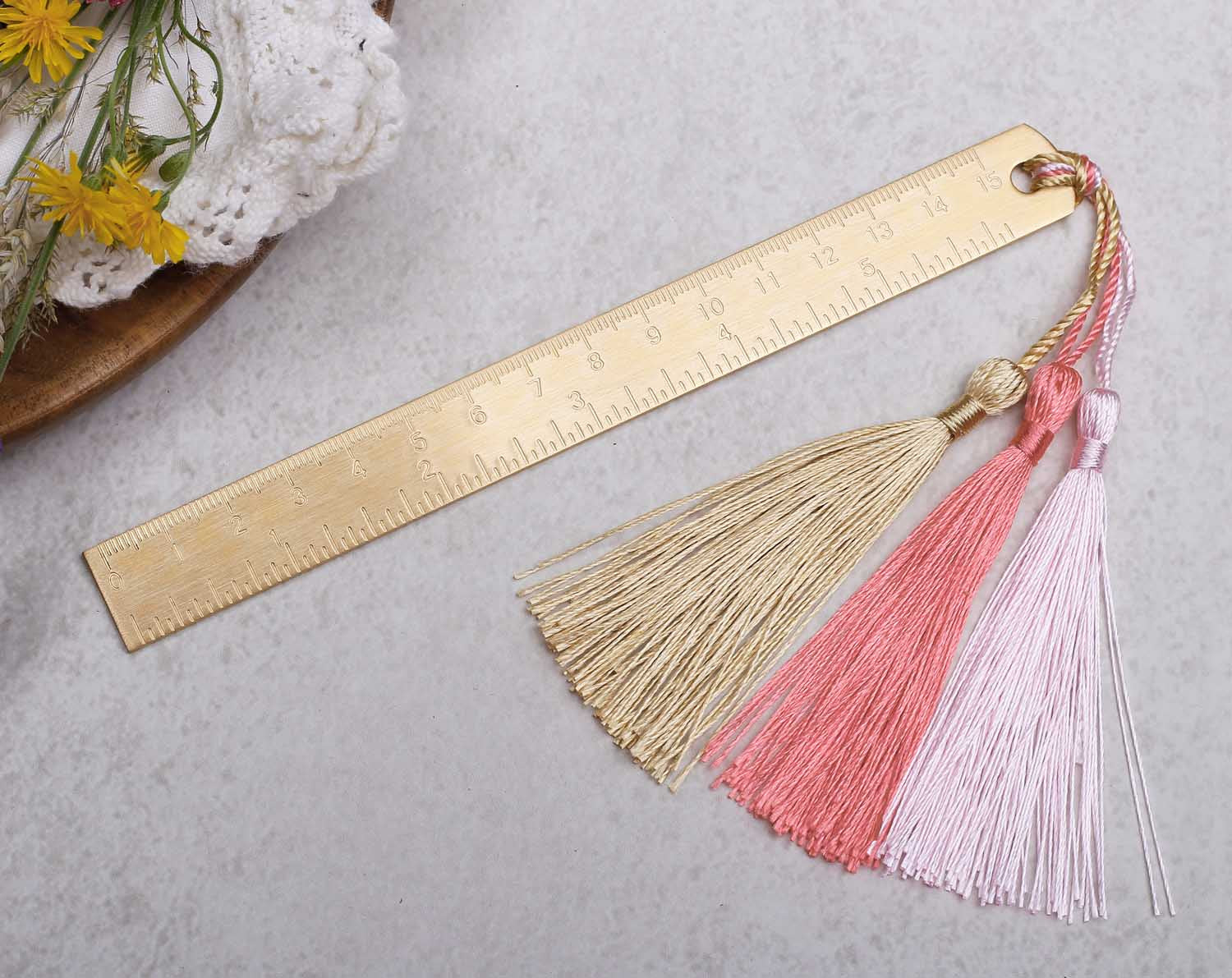 gold metal ruler with pink tassels