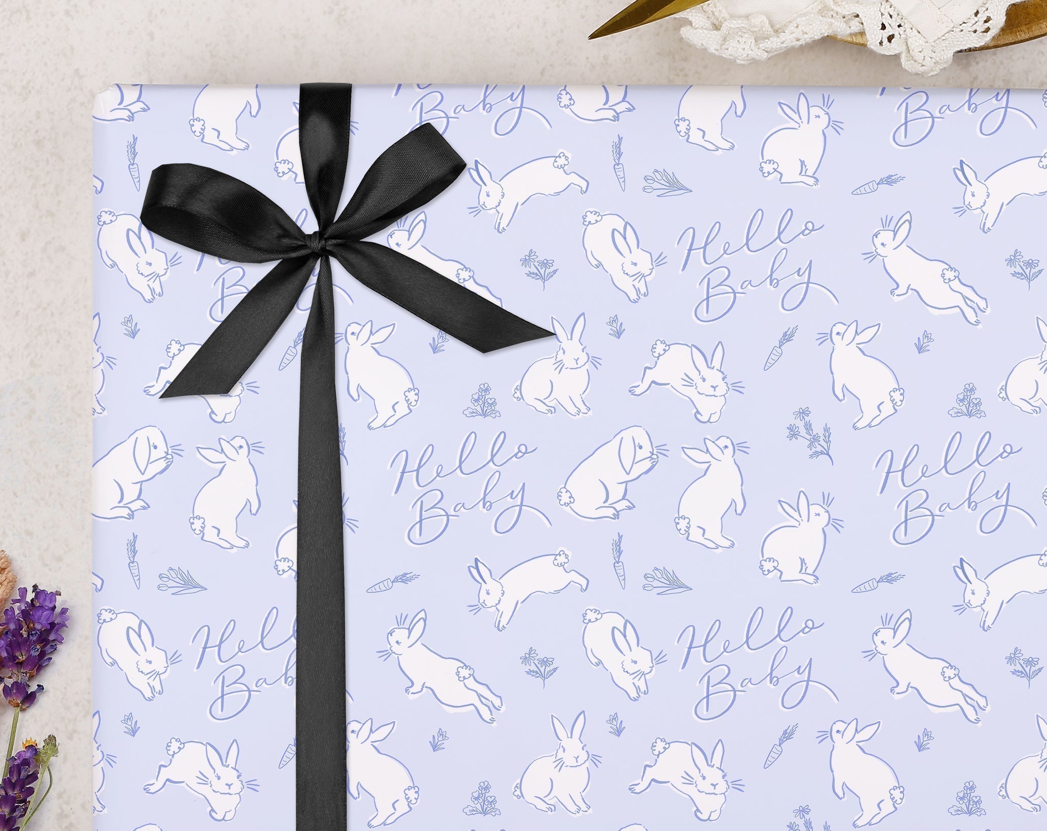 Thoughtful Baby Shower Gifting wrapped in pastel bunny patterned paper with a black ribbon.