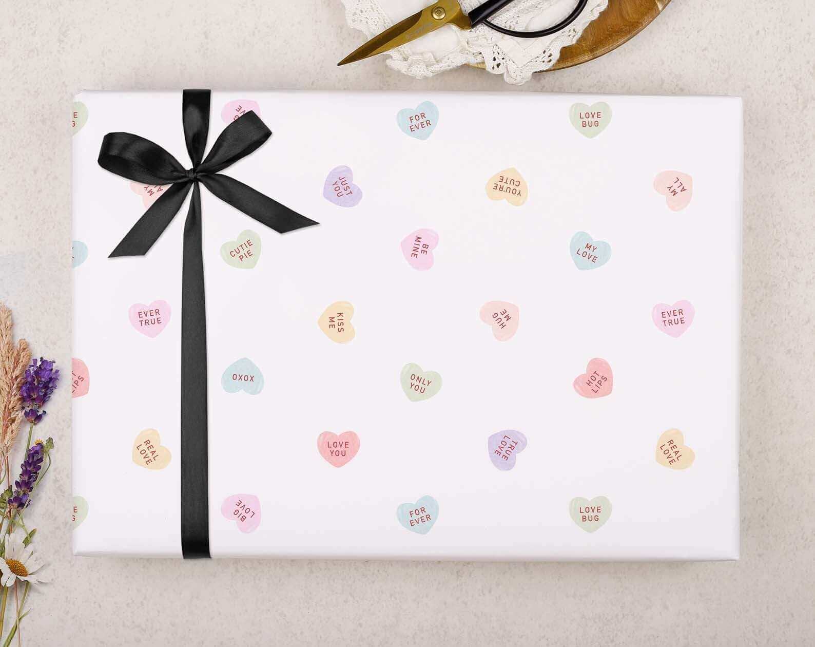 A beautifully wrapped gift with plastic-free packaging, featuring a white background and colourful love heart design.