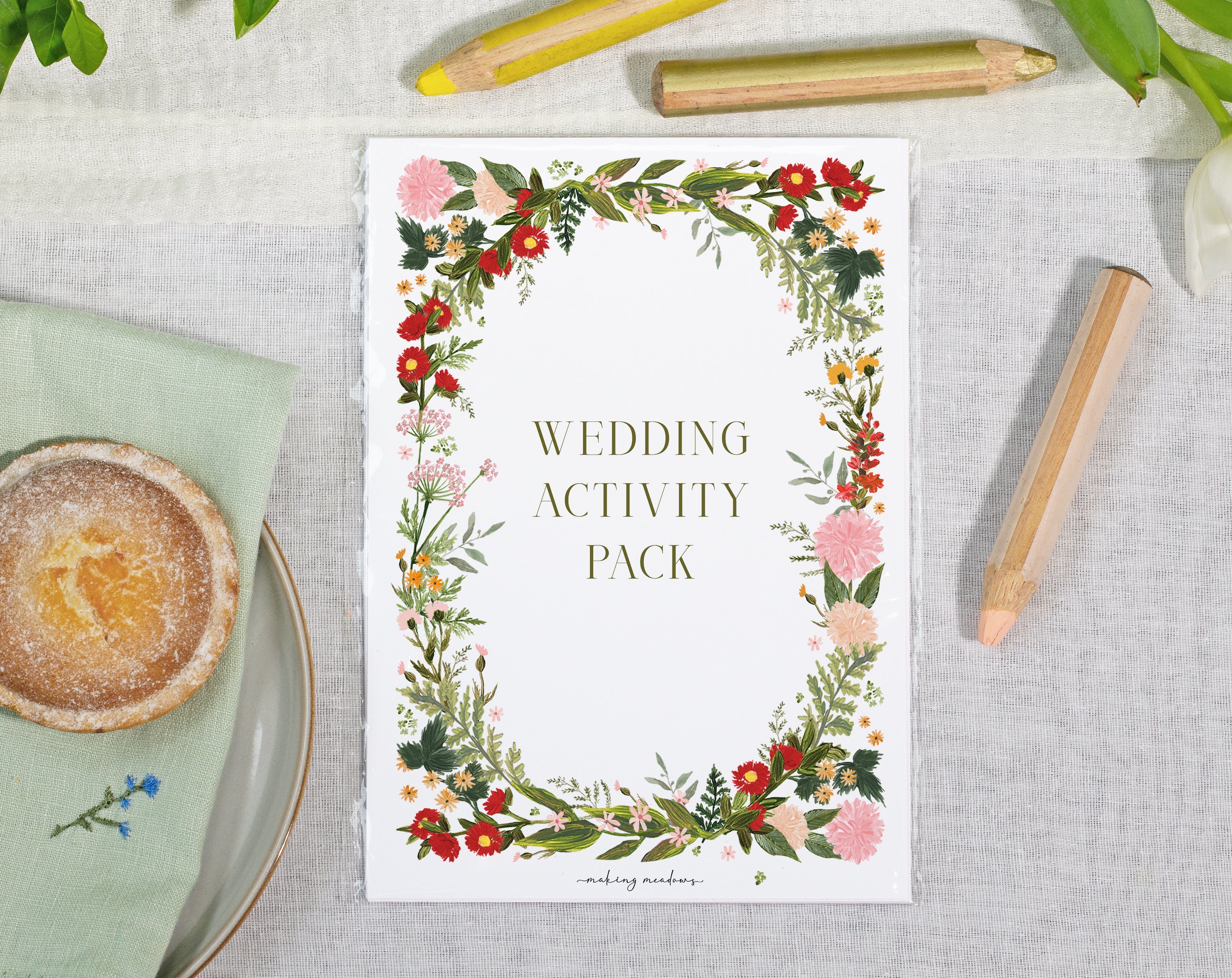 Wedding Activity Packs for children displayed on a table with floral design, including pencils and a snack.