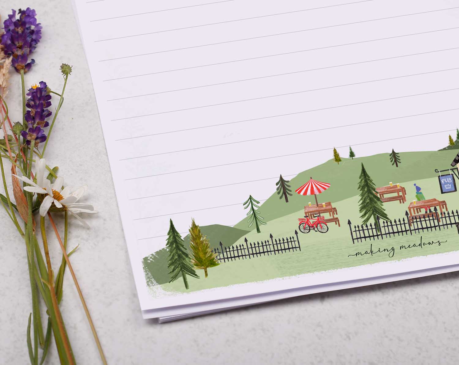 A4 letter writing paper sheets with a cute illustration of a countryside pub surrounded by rolling hills.
