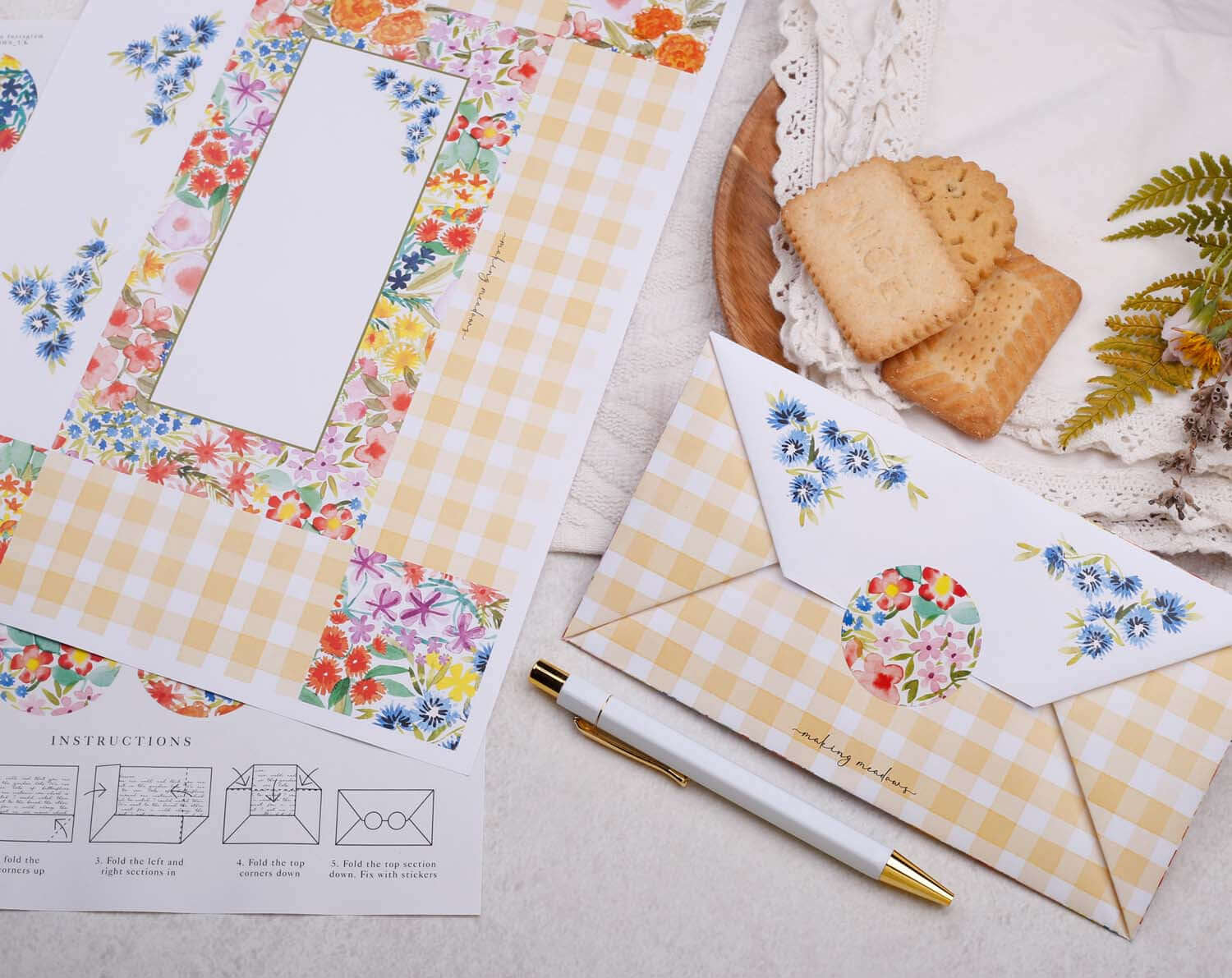 A4 origami writing paper set with watercolor flowers, envelope instructions, and decorative envelope on a table.