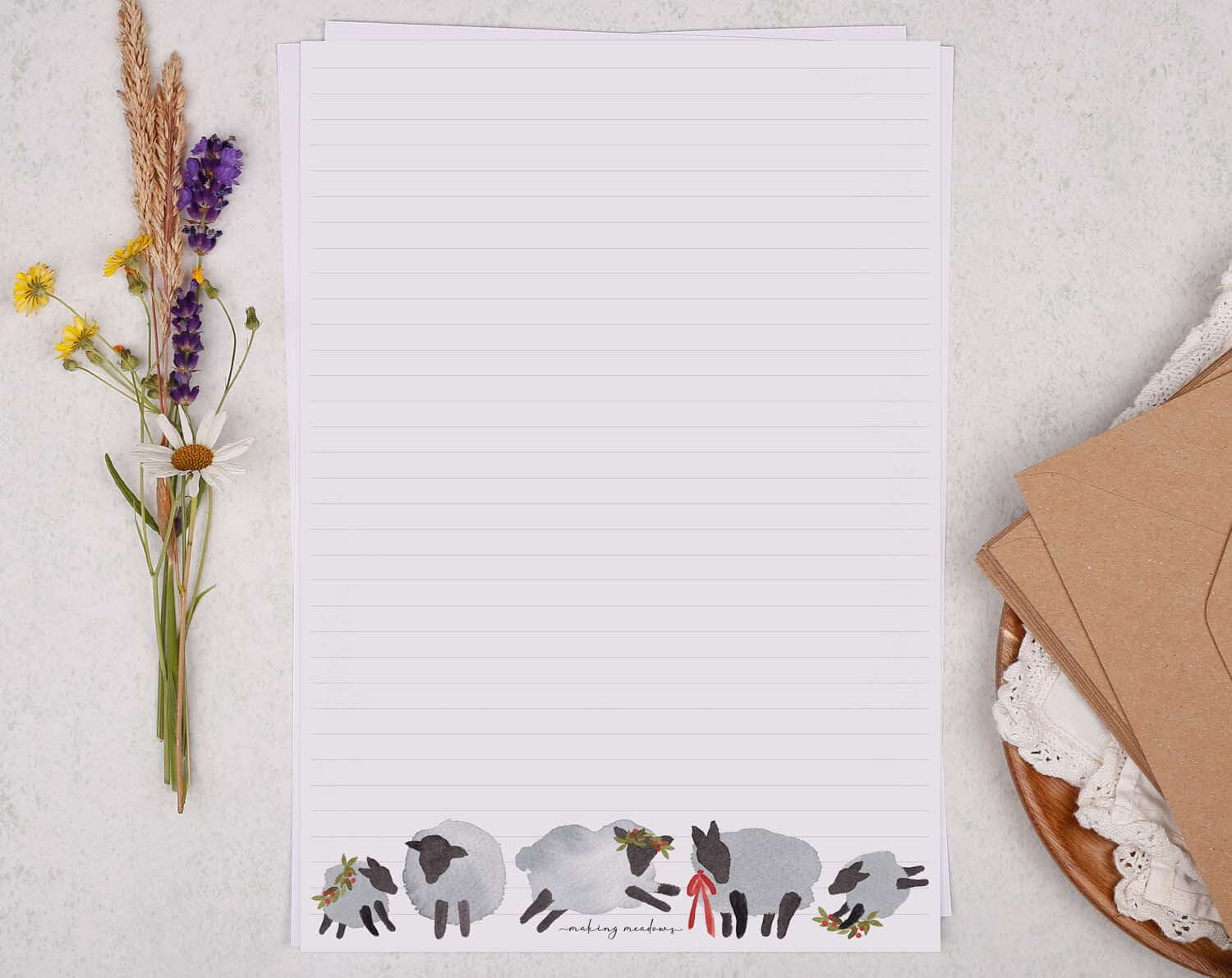 A4 writing paper with Festive Sheep displayed beside dried flowers and envelopes.